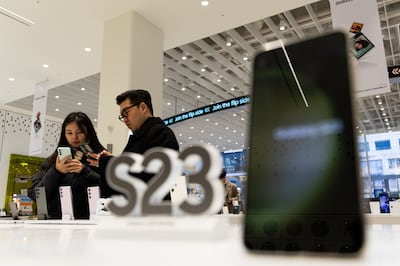 Customers try Samsung Galaxy S23 smartphones at a store in Seoul. Bloomberg