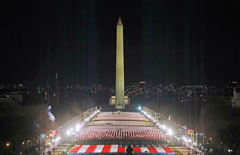 Spotlights illuminate the sky from the 'Field of Flags' on the National Mall in honour of the upcoming inauguration of US President-elect Joe Biden in Washington. Reuters