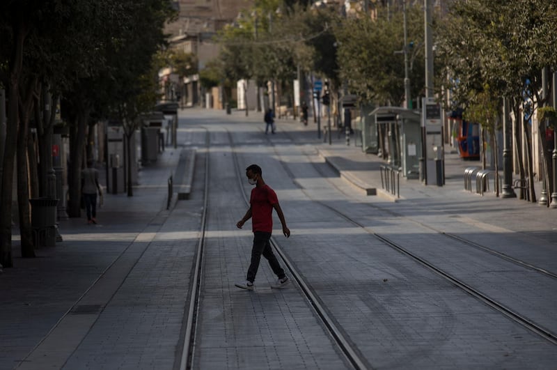 An Israeli man crosses the empty street during the first hours of a the three weeks lockdown amid the Jewish holiday season as the country faces a surge in Covid-19 cases, in Jerusalem, Israel. The Israeli cabinet approved a full three-week lockdown aimed to prevent the spread of the outbreak. EPA