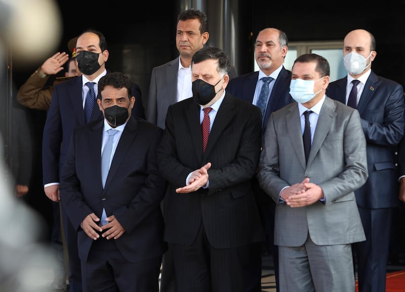 Libyan Prime Minister Abdul Hamid Dbeibah, front left, and former head of Libya’s UN-backed government Fayez Sarraj, center, and Mohamed al-Menfi, right, head of the new interim government’s presidential council, stand together after a ceremony marking the official handover of power to the new government, in Tripoli, Libya. AP Photo