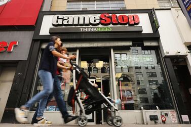 People pass a GameStop store in lower Manhattan in New York City. GameStop has announced that they will be closing between 180 and 200 stores before the end of the fiscal year due to a drop in sales. Getty Images/AFP. 