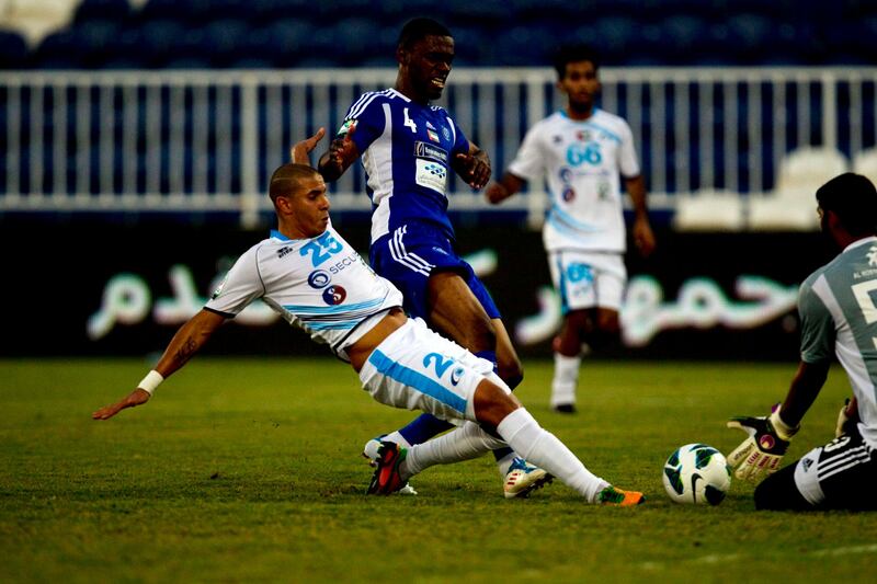 Abu Dhabi, United Arab Emirates, November 9, 2012:    Bani Yas' Mohamed Zidan Abdalla, left, lunges for the loose ball as Al Nasr's goalkeeper Abdualla Moosa Ali, right, grabs the ball while battling with  Helal Saeed, #4, during their Pro League match at Baniyas Stadium in Abu Dhabi on November 9, 2012. Christopher Pike / The National
