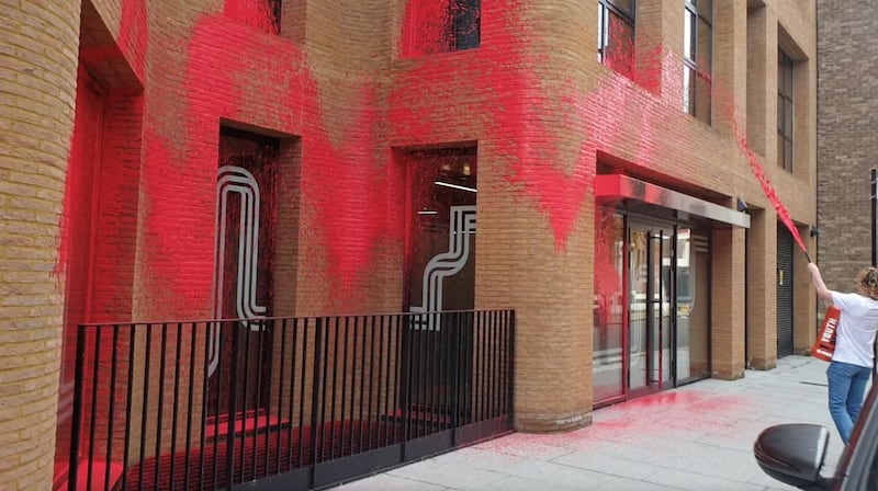 A Youth Demand supporter sprays the building with red paint. Reuters