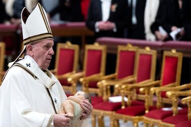 Pope Francis holds a statue of the baby Jesus as he leads the Christmas Holy Mass in Saint Peter’s Basilica at the Vatican on 24 December 2019. EPA