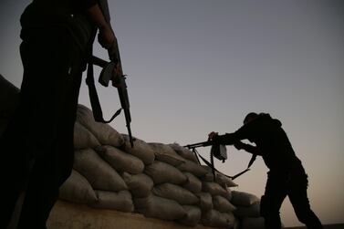 Turkish-backed Syrian fighters take up an armed position with sandbags along the frontline with SDF forces. AFP 