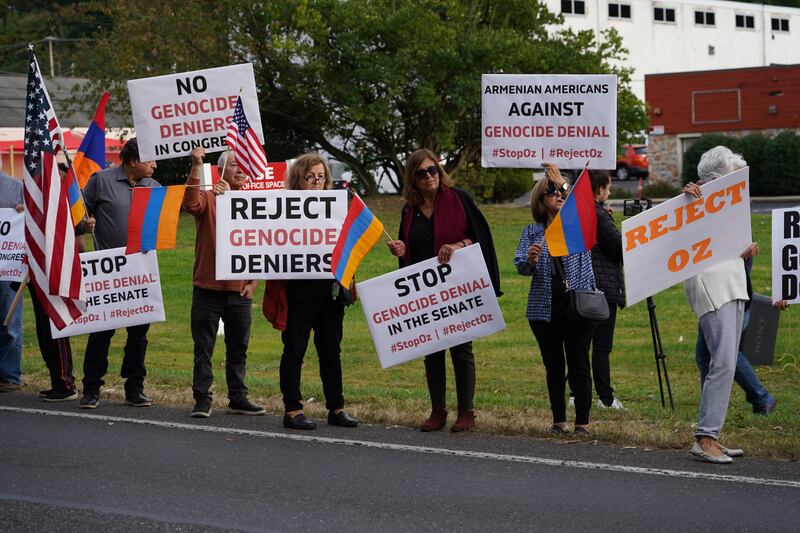 Demonstrators hold up placards to protest against Dr Oz's campaign.