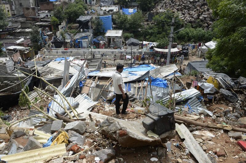 An Indian man inspects the site of a house collapse in the Singadikunta slum area in Hyderabad. Noah Seelam / AFP Photo