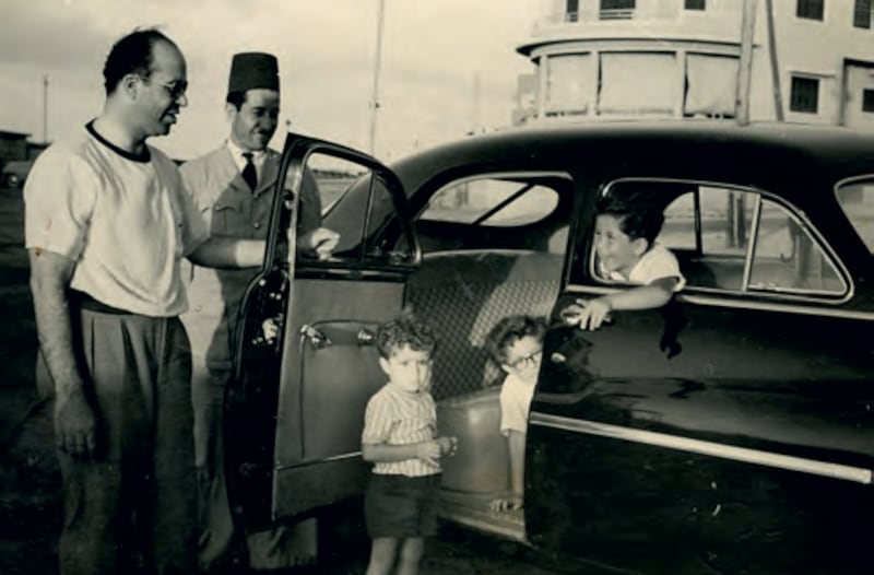 Mohamed Mansour and his brothers Ismail and Youssef explore their father's car while he watches. Photo: Hawthorn