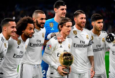 Real Madrid's Croatian midfielder Luka Modric (C) poses with his Ballon d'Or trophy and teammates before the Spanish League football match between Real Madrid and Rayo Vallecano at the Santiago Bernabeu stadium in Madrid on December 15, 2018. / AFP / GABRIEL BOUYS                     
