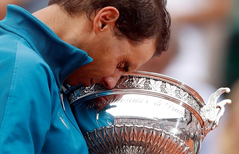 epa06799089 Rafael Nadal of Spain celebrates with the trophy after winning his 11th French Open title against Dominic Thiem of Austria during their men’s final match during the French Open tennis tournament at Roland Garros in Paris, France, 10 June 2018.  EPA/YOAN VALAT