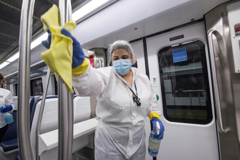 A worker from the railway cleaning services disinfects a grip bar in a train wagon in Palma de Mallorca, Balearic Islands, Spain.  EPA