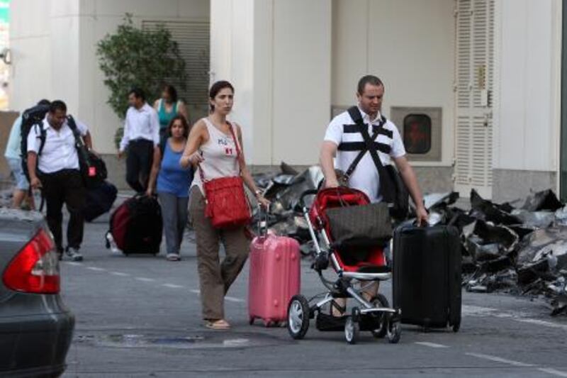 DUBAI , UNITED ARAB EMIRATES  Ð  Nov 19 : Some of the residents coming out with their belongings after police and Dubai Civil Defense gave permission to go inside the Tamweel tower in Jumeirah Lake Towers in Dubai. Fire broke out in the Tamweel tower around 2am on Sunday. ( Pawan Singh / The National ) For News. Story by Martin
