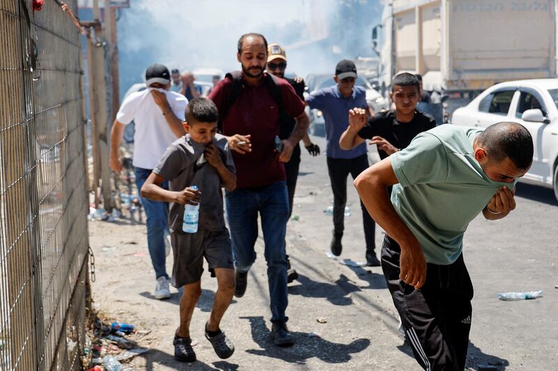 Jenin residents flee as tear gas is fired. Reuters