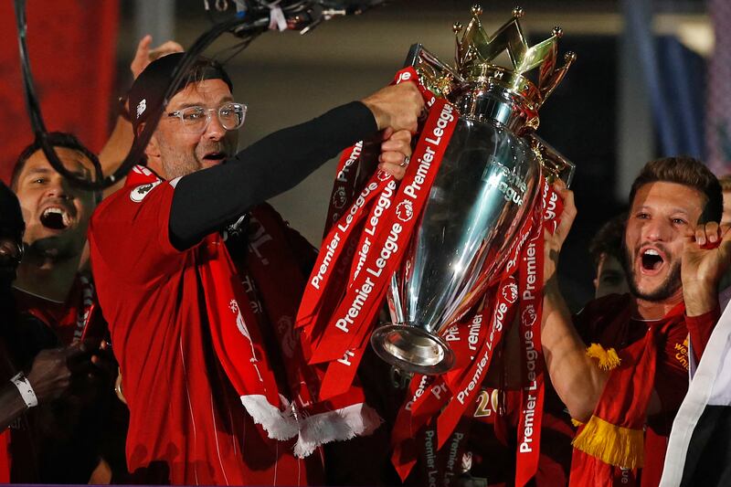 Jurgen Klopp and Liverpool's midfielder Adam Lallana with the Premier League trophy during the presentation ceremony at Anfield on July 22, 2020. AFP