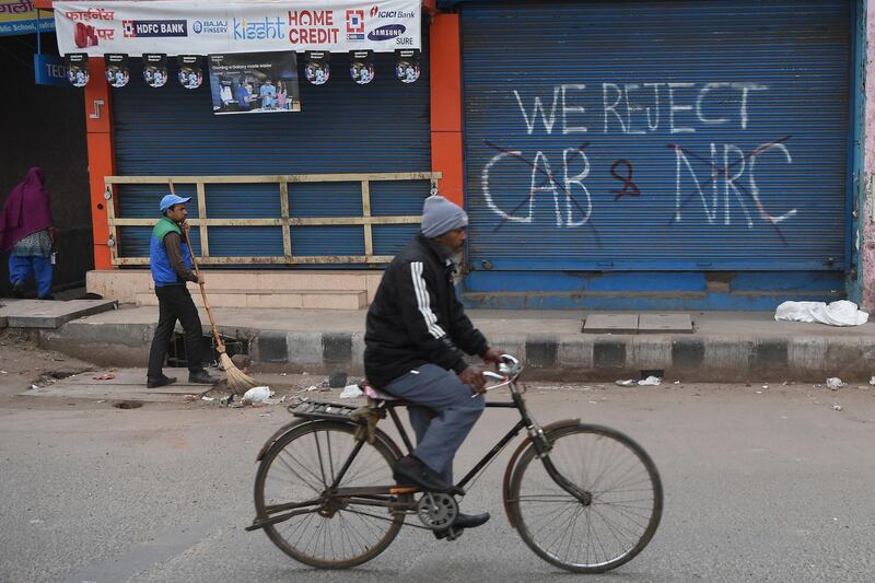 A man cycles past graffiti against India's Citizenship Amendment Act in New Delhi. AFP