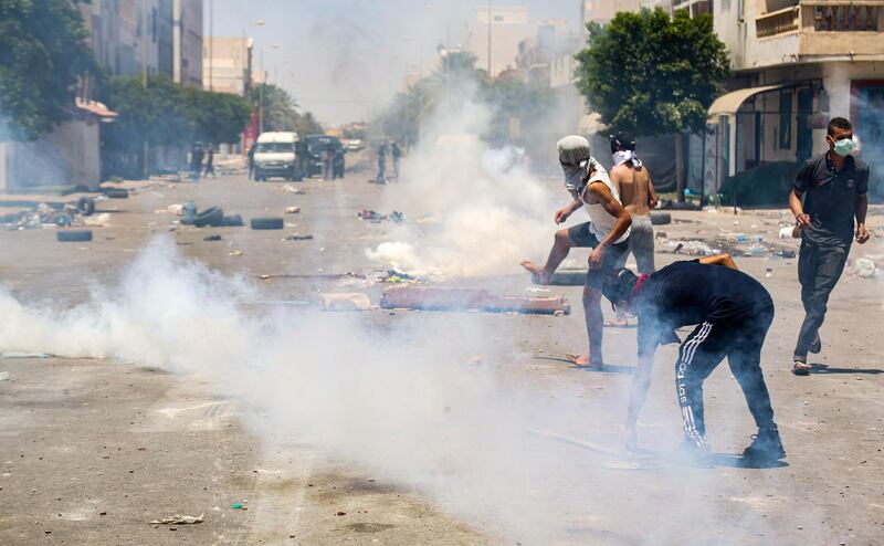 Protesters from Tunisia's Tataouine region throw stones as they clash with security forces.  AFP
