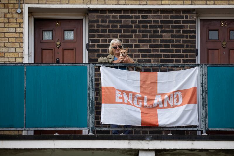 A woman and her dog show their support for the national team on Kirby Estate in London's East End.