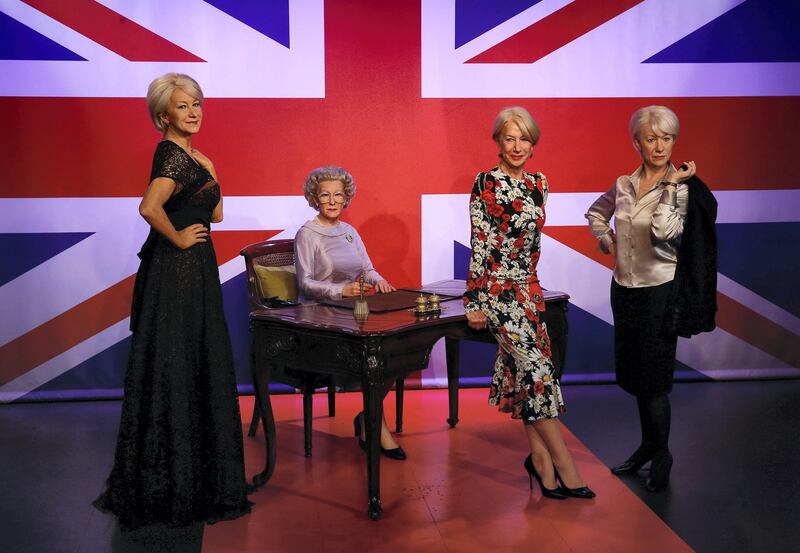 British actress Helen Mirren, (2R) poses with three waxwork models of herself, at the Madame Tussauds attraction in London on July 30, 2015. The models depict Mirren as herself attending a 'Red Carpet' event (L), playing the role of Britain's Queen Elizabeth II (2L) in the film 'The Queen', and as the character Jane Tennison from the television show 'Prime Suspect' (R).    AFP PHOTO / JUSTIN TALLIS (Photo by JUSTIN TALLIS / AFP)