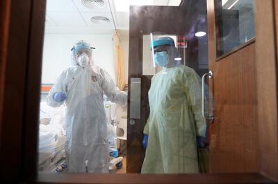 DUBAI, UNITED ARAB EMIRATES , April 26– 2020 :- Dr. Adel Alsisi, Consultant Critical Care Medicine, Chief Medical Officer, Prime Hospital wearing PPE kit (left) monitoring the situation of COVID-19 patient at the isolation ICU ward at the Prime Hospital on airport road in Al Garhoud in Dubai . (Pawan Singh / The National) For News/Standalone/Online/Instagram/Stock.  Story by Nick Webster