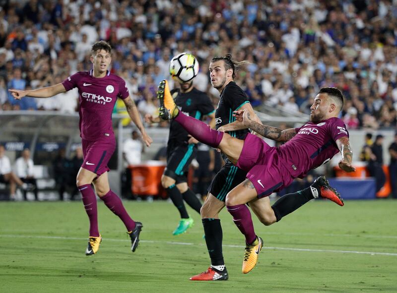 Manchester City's Nicolas Otamendi, front, kicks the ball away from Real Madrid's Gareth Bale. Jae C Hong / AP Photo
