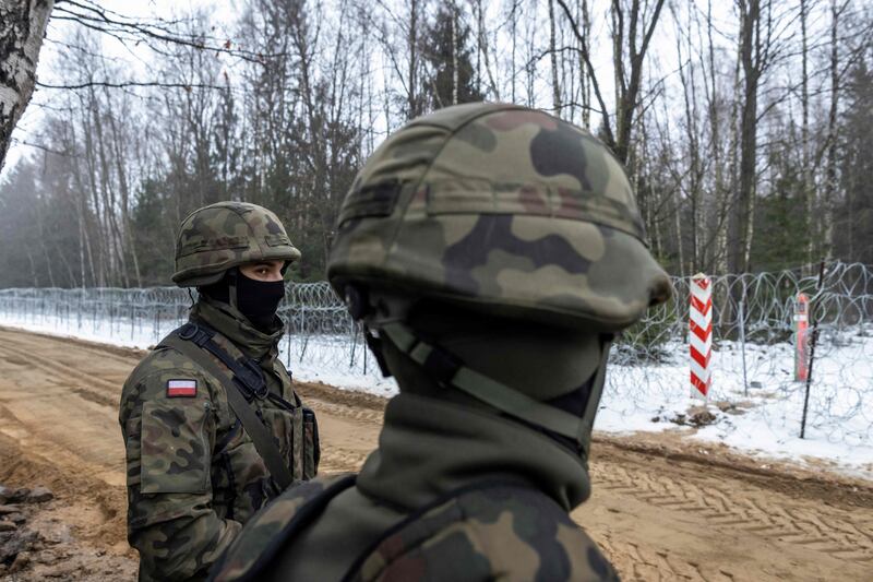 Polish soldiers oversee the construction of a barrier along the border with Belarus in Tolcze, north-east Poland. AFP