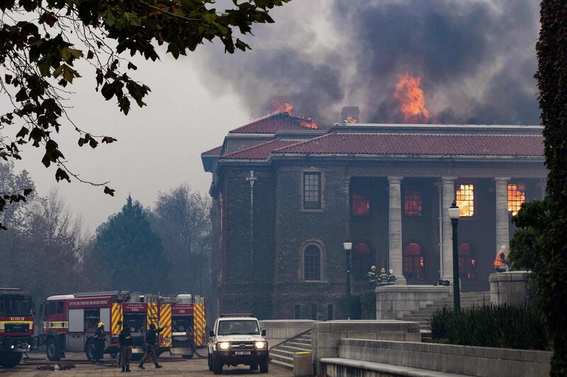 Firefighters attempt to extinguish a fire in the Jagger Library, at the University of Cape Town, after a forest fire spread down the foothills of Table Mountain, in Cape Town, South Africa, on Sunday. AFP