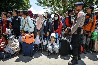 Residents wait behind a line before boarding military airplanes for evacuations at the Mutiara SIS Al-Jufrie Airport in Palu, Indonesia's Central Sulawesi on October 6, 2018, following the September 28 earthquake and tsunami.  The city of Palu on Sulawesi island has been left in ruins after it was hit by a powerful quake and a wall of water which razed whole neighbourhoods to the ground, with the official death toll now 1,571. / AFP / MOHD RASFAN
