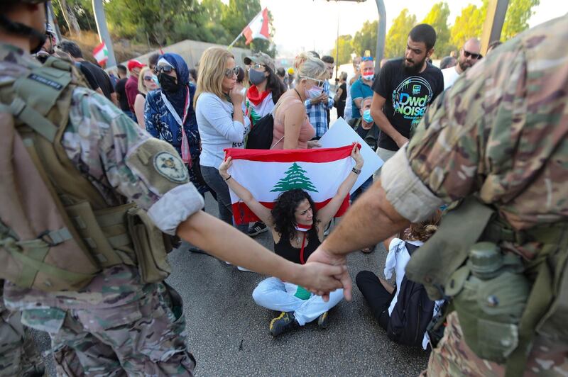 Lebanese protesters face members of the security forces during a demonstration against the lack of progress in a probe by authorities into a monster blast that ravaged swathes of the capital 40 days ago, near the presidential palace in Baabda, east of the capital Beirut.   AFP