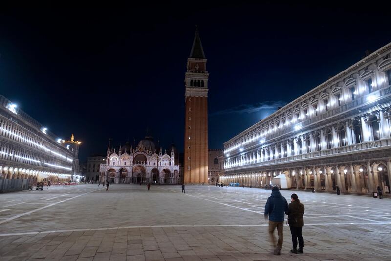 People walk in an almost empty St. Mark's Square in Venice, Italy. AP