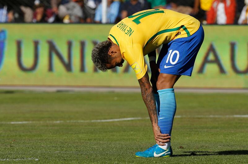 Neymar adjusts his shin guard during the match. Leo Correa / AP Photo