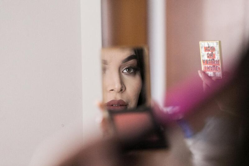 Eljammi Gozalli, beauty blogger and makeup artist is seen in the reflection of a mirror she is holding.  Reem Mohammed / The National