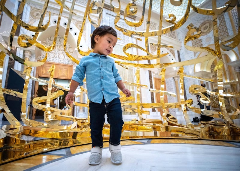 Abu Dhabi, United Arab Emirates, October  20, 2020.   Qasr Al Watan reopens to public tours on Tuesday with strict measures in place to limit the spread of Covid-19.  Tiago Freites, 2, an Abu Dhabi resident from Venezuela is amazed by the work of art by Mattar Bin Lahej entitled, The Power of Words, which is inspired by a quote from the late Sheikh Zayed bin Sultan Al Nahyan:
"Wealth is not money and oil.  Wealth lies in people, and is worthless if not dedicated to serve the people."
Victor Besa/The National
Section:  NA
Reporter: