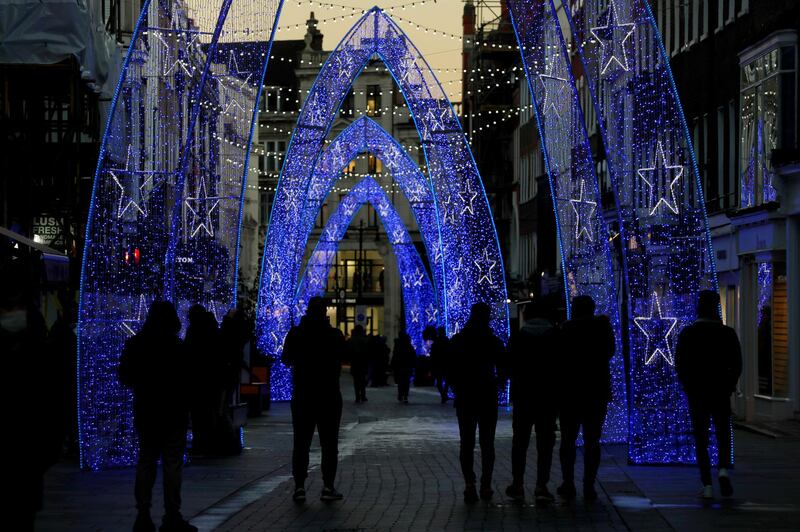 People stand to look as Christmas lights light up the streets of Mayfair. AP Photo