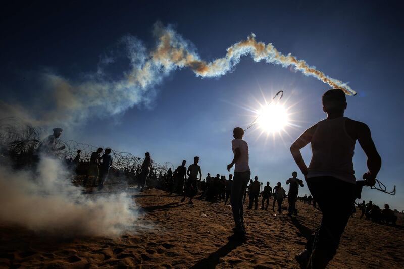 Palestinian youngsters use slingshots to hurl rocks at Israeli troops during clashes near Rafah in the southern Gaza Strip. AFP