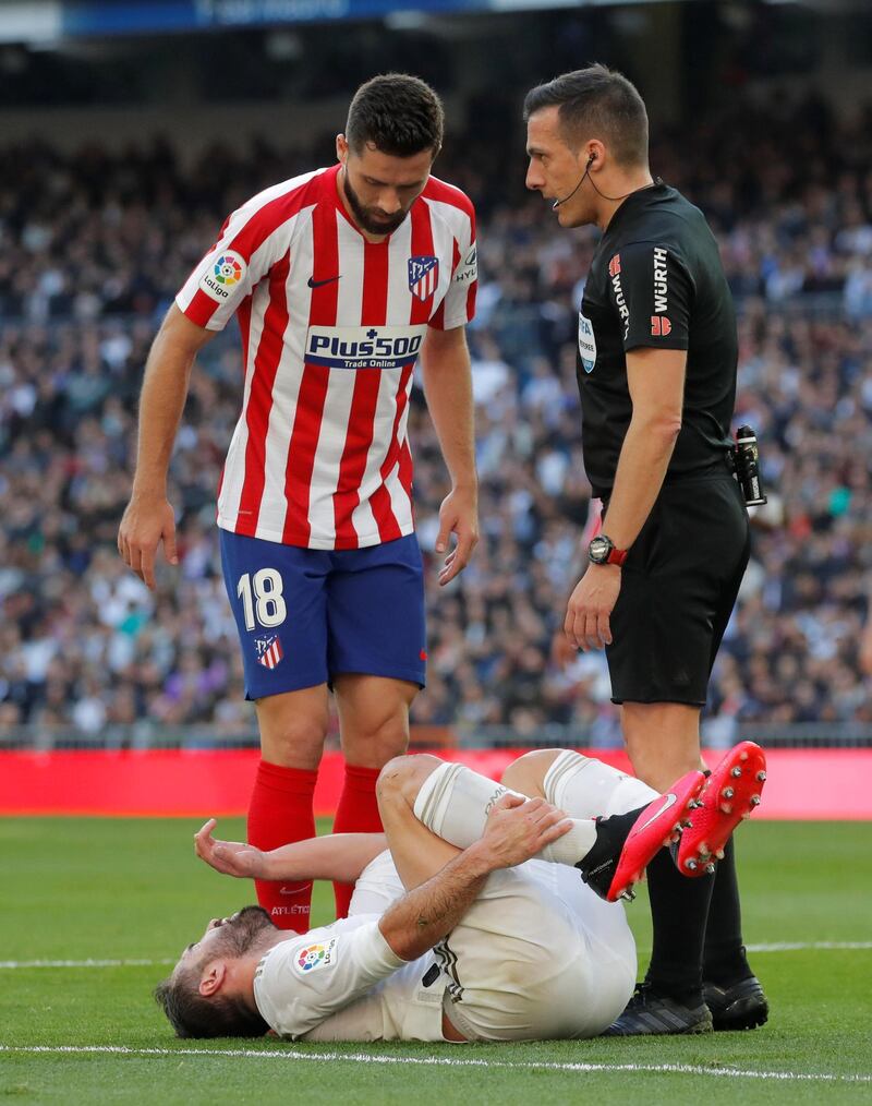 Atletico Madrid's Felipe watches as Real Madrid's Dani Carvajal grimaces in pain after sustaining an injury at the Santiago Bernabeu. Reuters