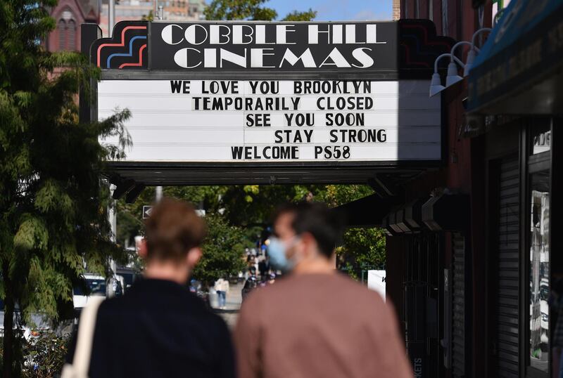 People walk past the Cobble Hill Cinemas movie theater in New York City.  With theaters closed in New York and Los Angeles and would-be movie goers across the country choosing to stay in, US cinemas are sending out a desperate SOS -- so far unanswered by Congress and studios. AFP