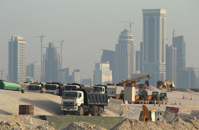 Lorries stand at a construction site across from skyscrapers in the budding new financial district in Doha. Qatar is heavily reliant on receiving construction materials through the Abu Samra border crossing. Sean Gallup/Getty Images