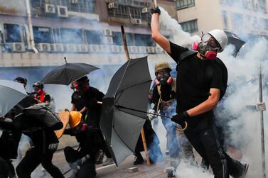A demonstrator throws back a tear gas canister as they clash with riot police during a protest in Hong Kong. Reuters