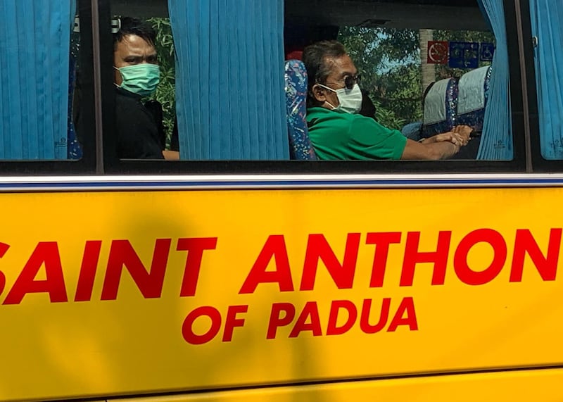 People wearing masks sit inside a bus in Manila, Philippines.  EPA