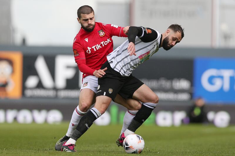 Wrexham's Elliot Lee and Notts County's Connell Rawlinson battle for the ball. PA