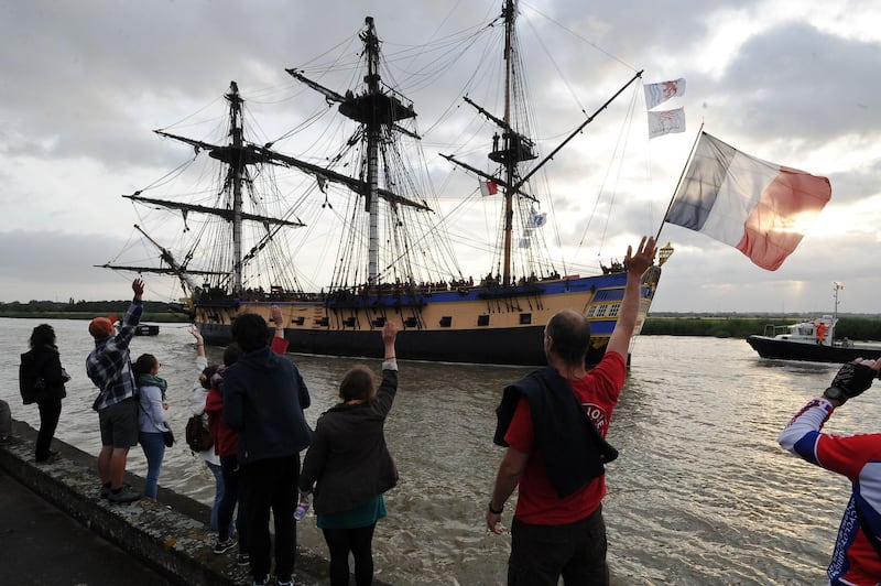 Spectators look on as the replica of the French navy frigate L'Hermione, which played a key role in the American Revolution, sails the waters of the Charente River returning to Rochefort, south-western France. Xavier Leoty / AFP
