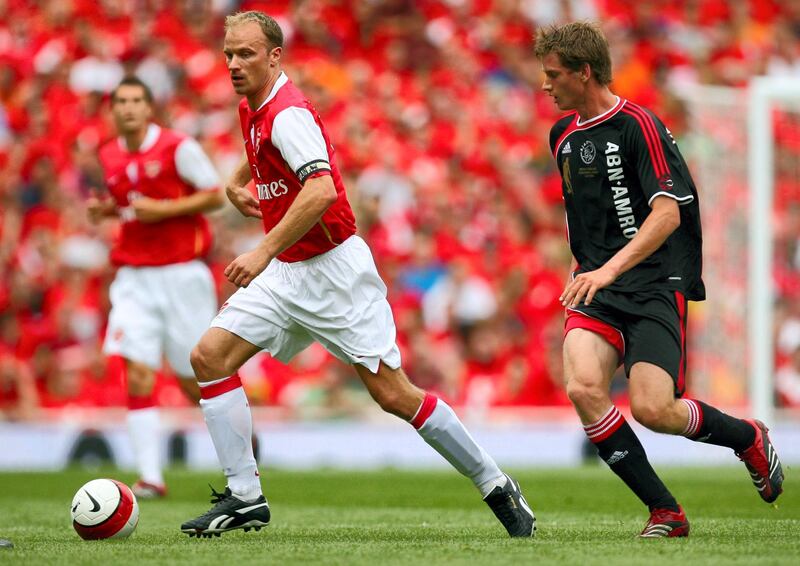 Dennis Bergkamp (L) of Arsenal is chased by Jan Vertonghen of Ajax during a pre season testimonial match at Emirates stadium in north London,  22 July 2006. The match played in honour of Arsenal's Dutch player Dennis Bergkamp who has served the club for 11 years and will retire after the game is the first match played at the club's new stadium. AFP PHOTO / ODD ANDERSEN (Photo by ODD ANDERSEN / AFP)