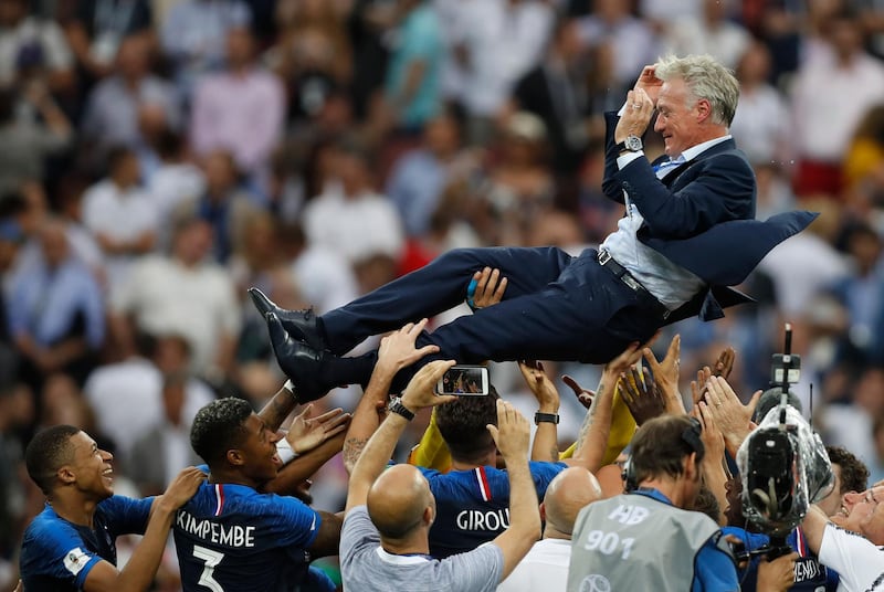 Coach Didier Deschamps is thrown into the air by his players. AP Photo