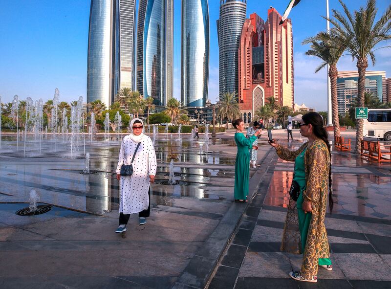 Visitors to the Emirates Palace Hotel fountain in Abu Dhabi take pictures. Photo: Victor Besa / The National