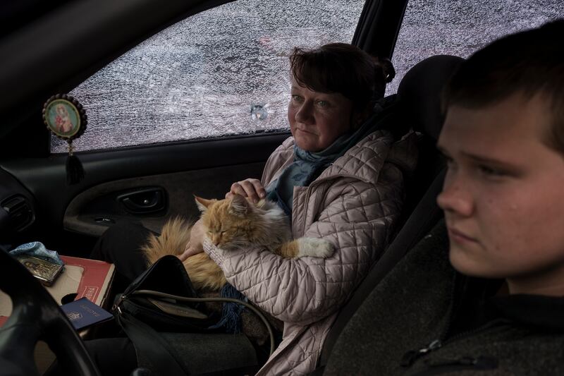 A family fleeing the village of Ruska Lozova in April 2022 arrive in their shrapnel-riddled car at a screening point in Kharkiv
