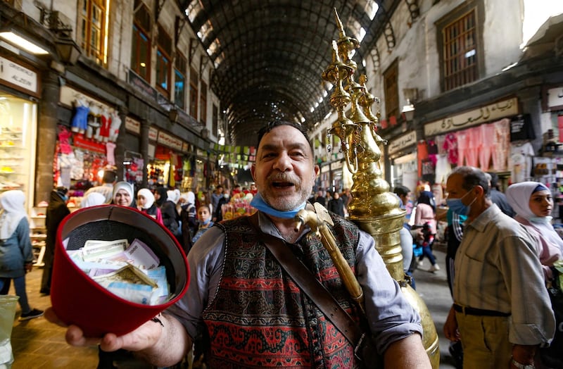 Ishaaq Kremed, a tamarind juice seller, calls on customers in the covered Hamidiyah Souq, Damascus. AFP