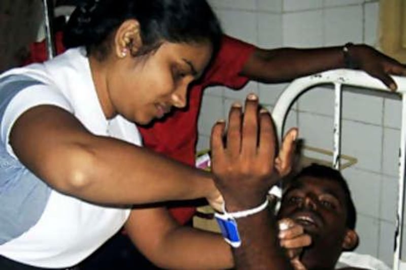 A nurse attends to a sailor at a hospital in the eastern port city of Trincomalee August 27, 2008, a day after he was injured during an aerial attack by Tamil Tiger separatists at a naval base. The Defence Ministry said a rebel aircraft belonging to the Liberation Tigers of Tamil Eelam dropped two bombs on Trincomalee, which government soldiers took full control of in March 2007. REUTERS/Stringer (SRI LANKA) *** Local Caption ***  COL02_SRILANKA-VIOL_0827_11.JPG