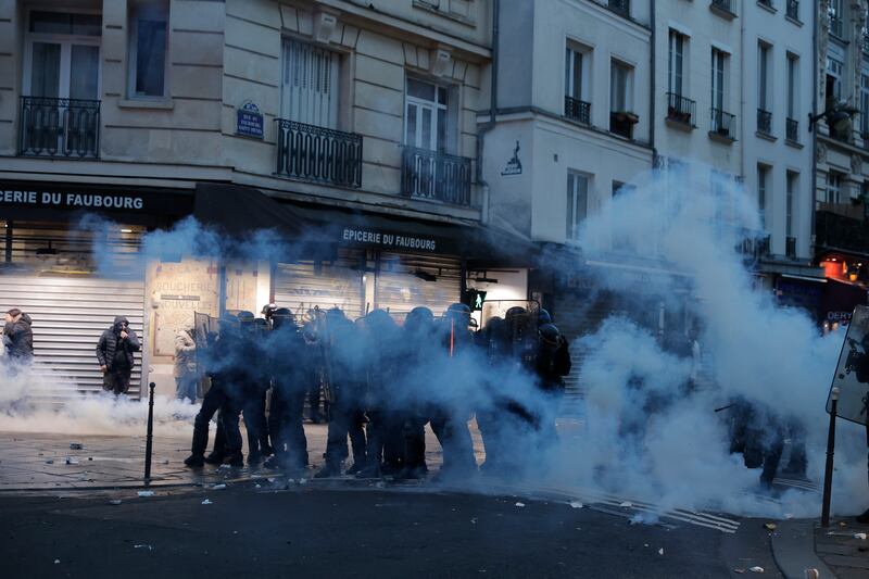 Anti-riot police stand in a cloud of tear gas after a protest by members of the Kurdish community turned violent, in central Paris. AP