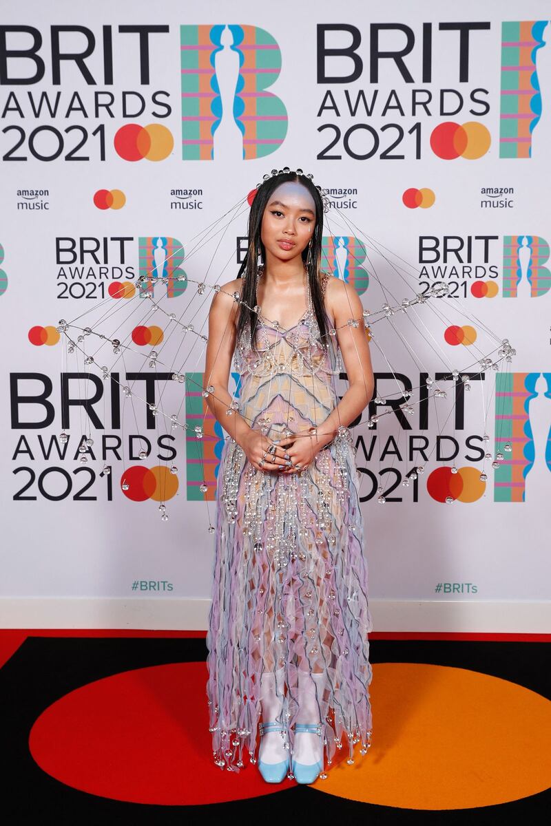 Griff poses on the red carpet in an embellished gown and matching headdress for the Brit Awards 2021. AFP