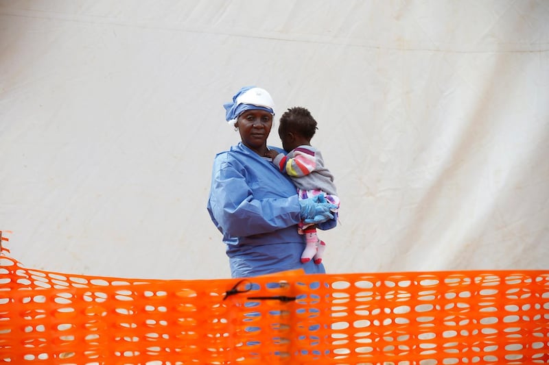 Victorine Siherya, an Ebola survivor working as a caregiver to babies who are confirmed Ebola cases, holds an infant outside the red zone at the Ebola treatment centre in Butembo, Democratic Republic of Congo, March 25, 2019. Picture taken March 25, 2019.REUTERS/Baz Ratner